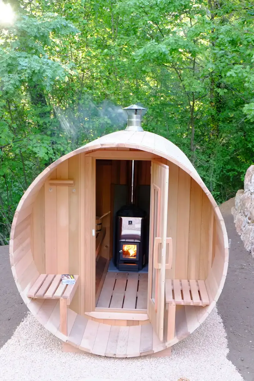 De sauna met open deur en brandende houtkachel
